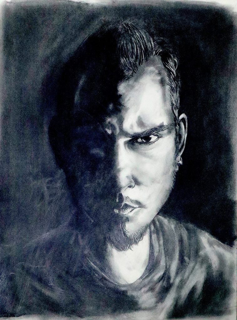 Charcoal drawing of the artist, portrait in harsh lighting from the right of the face and the left being in light , many different marks made to change the illusion in the dark side of the portrait, heavy blacks and highlights.