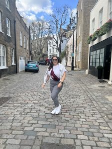 Chloe Allen standing outside on a brick street in casual clothes.