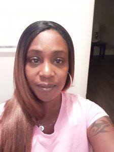 Selfie of Rickia Williams wearing a pink t-shirt and jewelry.