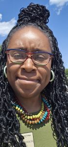 Yolanda Johnson standing outside with a green shirt and colorful jewelry.