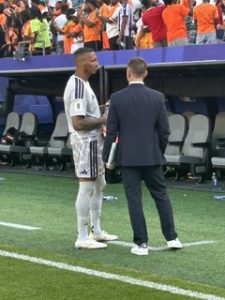 World Cup Player: World Cup player on the field with a World Cup employee.