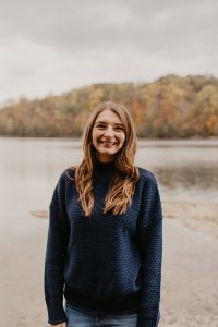 Stephanie Pinckney wearing jeans and a sweater as she stands outside smiling at the camera.