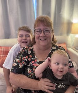 Debbie Ake posing with her two grandchildren.