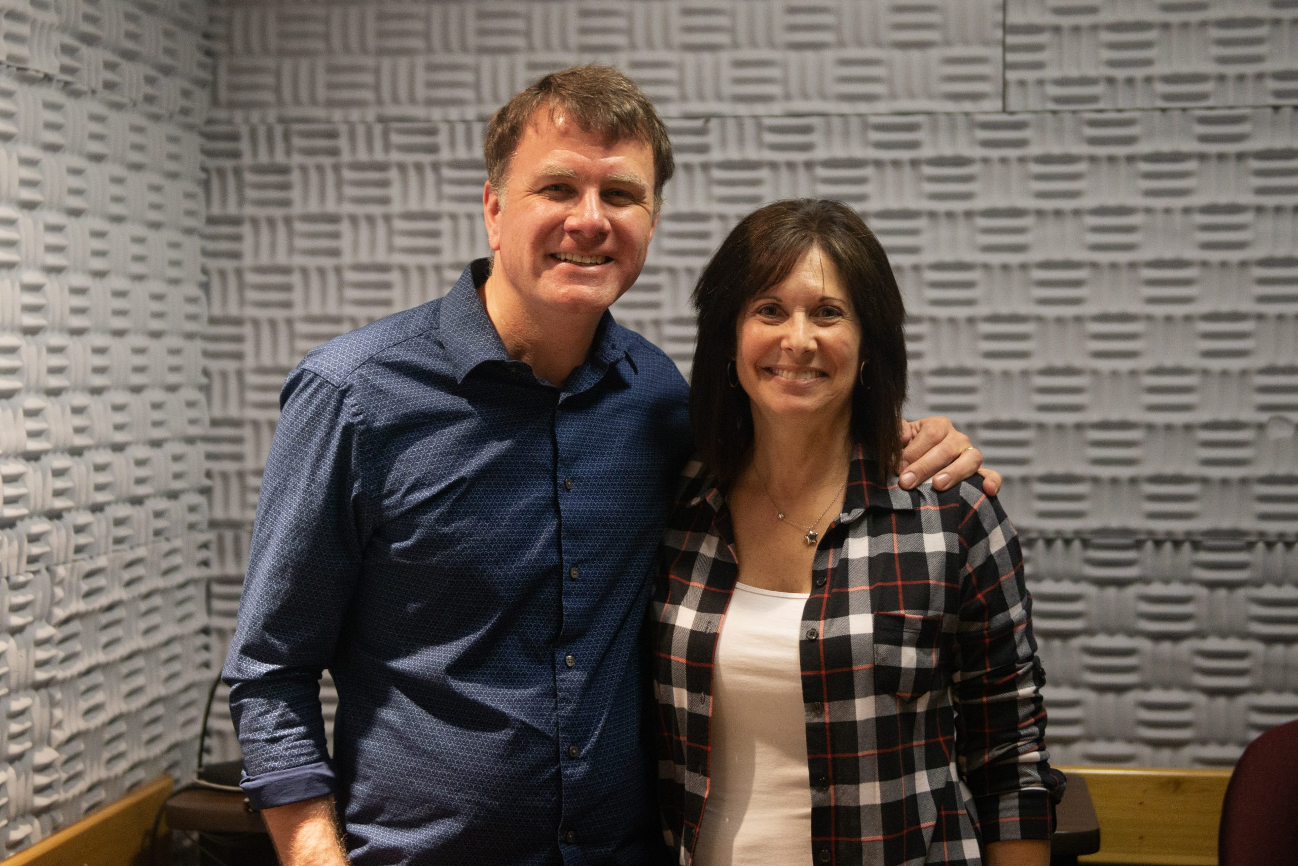 two people, one in a blue shirt and one in a black and white checkered shirt, with the text