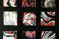 A large square board displaying nine indivdual, smaller squares, each painted with an abstract design. Using only a hairbrush and a piece of string, red, black, grays and whites were spread around to make a radial design connecting each piece into a finished product.