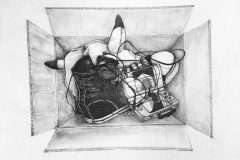The piece is a black and white, pencil drawing of a still life. There is a cardboard box sitting on the ground, being looked into. The box is filled with scattered items, including a converse shoe on top of a pikachu hat, earbuds, a pair of glasses, and a Nintendo DS.