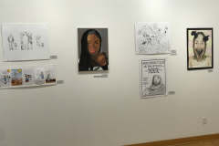 This is a photograph of the 44th annual student art exhibition installation. In this image we are seeing a small section of the left wall of the gallery with 6 pieces of art installed in the space.