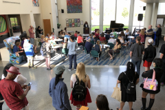 This image shows a group of people sitting at tables, listening to MCC President Dr. Deanna Burt-Nanna speaking during the award ceremony.