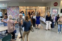 Image of artist opening reception, people outside the gallery talking.
