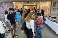 Image of artist opening reception, people outside the gallery talking.