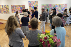 Image of Artist Reception, people watching Claire be interviewed by news station.