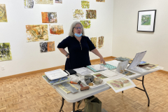 Image of artist giving lecture in gallery, showing examples of how she makes her artwork.