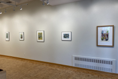 Installation shot of gallery, showing the right wall of the gallery, with five framed prints hung evenly on the wall.