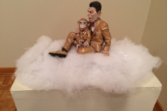 Detail image of Elliott Arkin sculpture that is of Ronald Regan and a chimpanzee sit on a bed of cotton representing clouds.