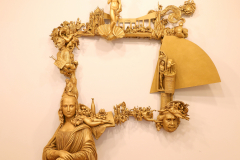 Detail image of Elliott Arkin sculpture that is a frame that hangs on a wall, and it is made out of multiple art historical references, including the Mona Lisa, Andy Warhol's soup can, and Botticelli's Venus., and