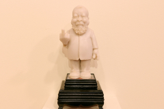 Detail image of Elliott Arkin sculpture that is of Artist Ai Weiwei, holding up his middle finger.