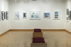 Photograph of Ira Epsteins work installed in the gallery. This image shows the galleries rear wall, and 11 framed pieces are hung down the wall. All the works are modified book pages and contain colorful ink on them.