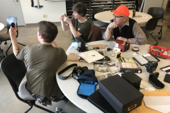 Artist Joe Ziolkowski working with two students creating pinholes for their digital cameras.