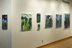 Installation shot of Judy Gohringers Mercer Gallery exhibition. This image shows the left gallery wall, on which are hung seven colorful landscape paintings in various sizes.