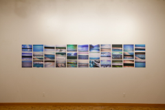 Installation shot of Margaret LeJeune Exhibition. This image shows the rear gallery wall, which was an installation on the wall of images of TV screens playing travel videos.