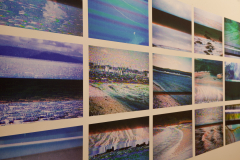 Installation shot of Margaret LeJeune Exhibition. This image shows a close up detail  of the rear gallery wall, which was an installation on the wall of images of TV screens playing travel videos.