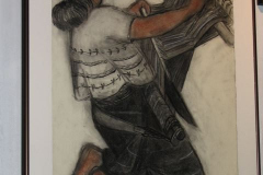 Installation shot of an image of a woman working with a loom.