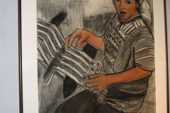 Installation shot of an image of a woman working with a loom.