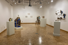 Installation photography of Nate Hodge Exhibition. In the image we see  a wide shot of the whole gallery, including six various sculptures , three small drawings on the back wall, and a large wall sculpture hanging on the right hand side.
