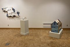 Installation photography of Nate Hodge Exhibition. In the image we see  a large wall sculpture hanging on the left, a small sculpture on a pedestal  in the center, and a large floor sculpture on the right.
