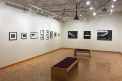 Installation shot of right  and rear gallery wall containing 13 comic illustrations.