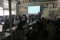 Image of Artist Nicholas Gurewitch lecturing in a classroom with students observing.