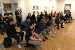 Image of Pat Bacon lecturing in the gallery with a number of people watching.