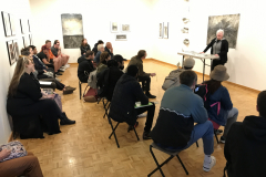 Image of Pat Bacon lecturing in the gallery with a number of people watching.