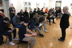 Image of Pat Bacon lecturing in the gallery with a number of people watching.