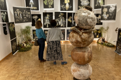 Photograph from the artist reception for Patti Russotti. Two people talk at the back of the gallery.