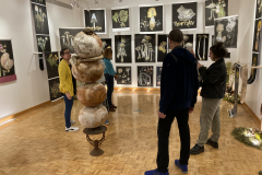 Photograph from the artist reception for Patti Russotti. Five people talk at the back of the gallery.