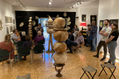 Image of artist Patti Russotti speaking about her work with a group of visitors.