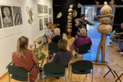 Image of artist Patti Russotti speaking about her work with a group of visitors.