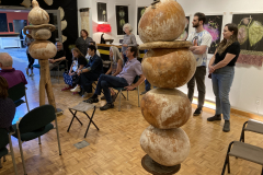 Image of artist Patti Russotti speaking about her work with a group of visitors.