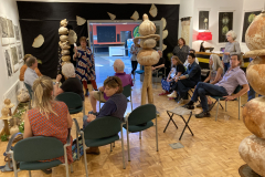 Image of artist Patti Russotti speaking about her work with a group of visitors.
