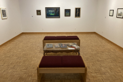 image of the RIT Faculty Illustration Faculty Exhibition.  This image shows th eexhibition, includiing the seats and table with books on them