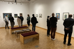 An image from th eoprning reception, in which many people look at artwork.
