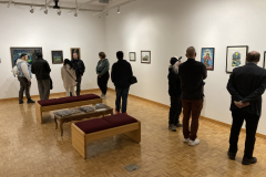 An image from th eoprning reception, in which many people look at artwork.