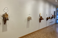 Detail image of the Robert Booth gallery installation, showing the right wall and showing six sculptures hanging on the wall.