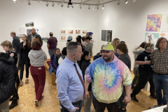 This image shows a group of people enjoying the opening reception in the gallery.