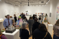 This image shows a group of people enjoying the opening reception in the gallery.