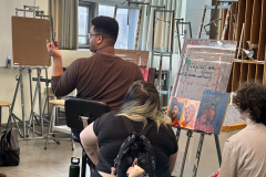 Photograph showing the artist demonstration in a painting one class.