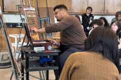 Photograph showing the artist demonstration in a painting one class.