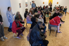 Photograph showing students watching the artist lecture.