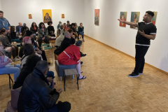 Photograph showing students watching the artist lecture.